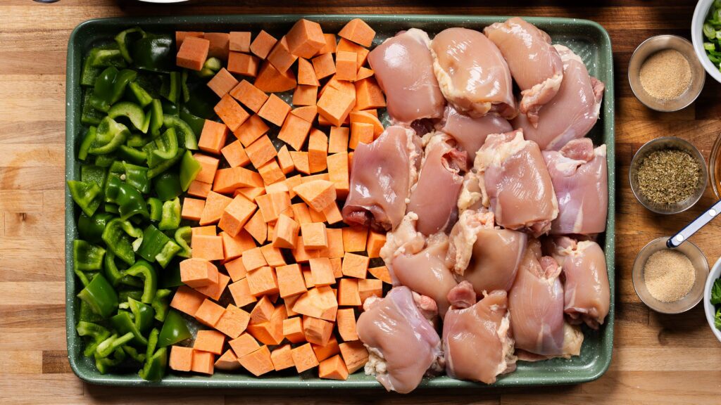 sheet pan chicken and veggies on a baking pan ready for the oven.