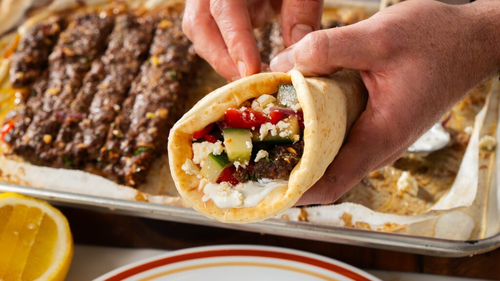 Pita wrapped beef kebab with tzatziki and Greek Salad.