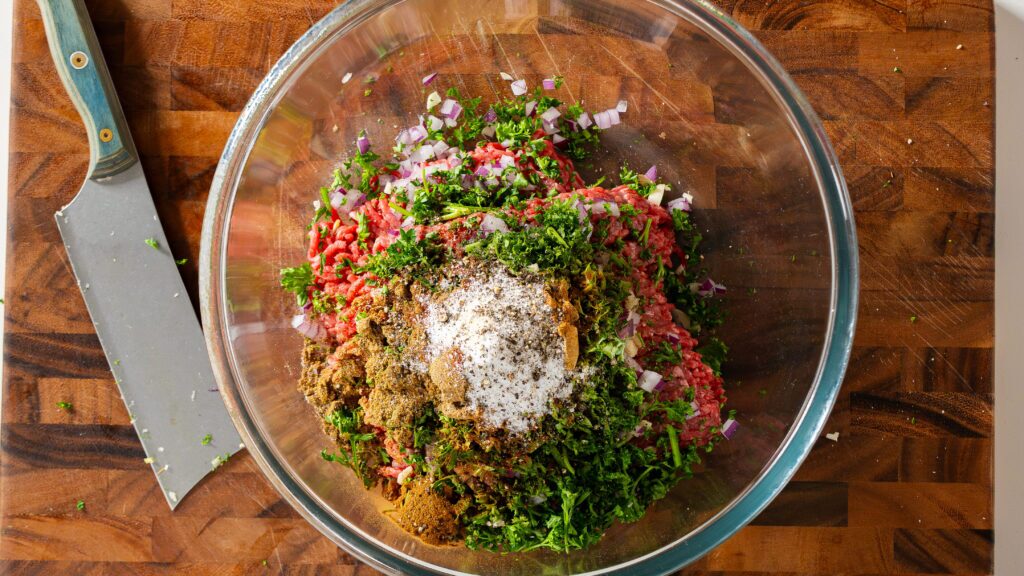 A bowl of beef kebab ingredients ready to be mixed.