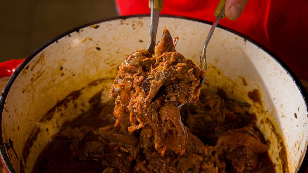 Shredded Korean braised beef in a large dutch oven.