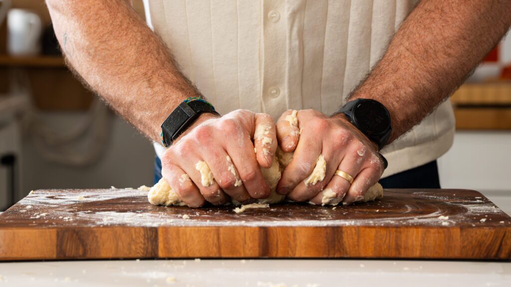 Kneading protein bread dough on a cutting board for a delicious protein bread recipe.