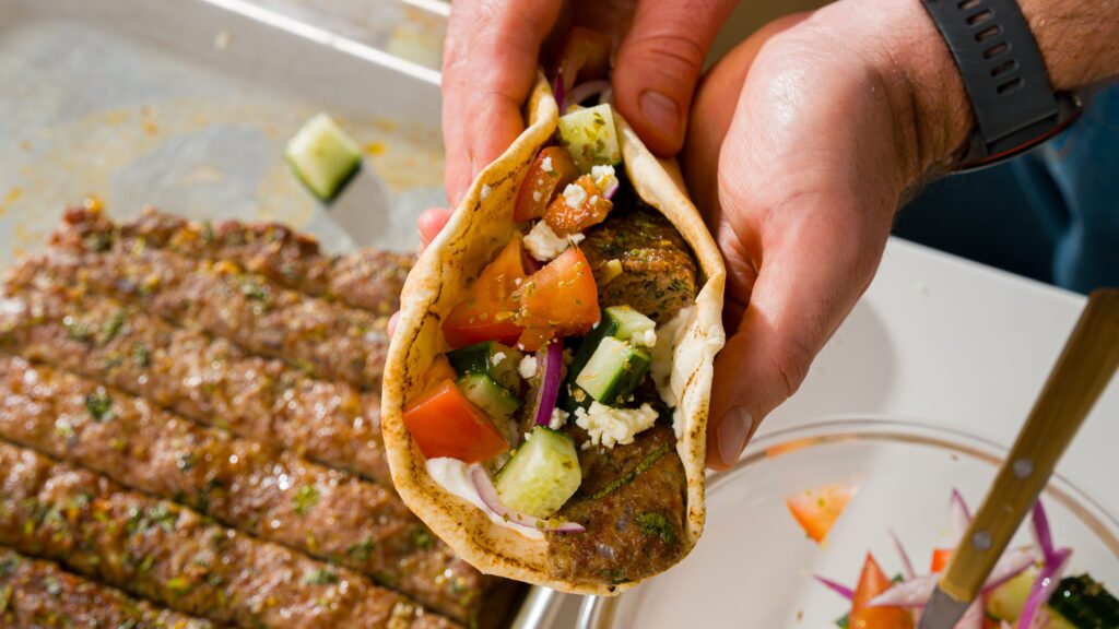 Chicken kebab wrapped in a pita with tzatziki and vegetables.