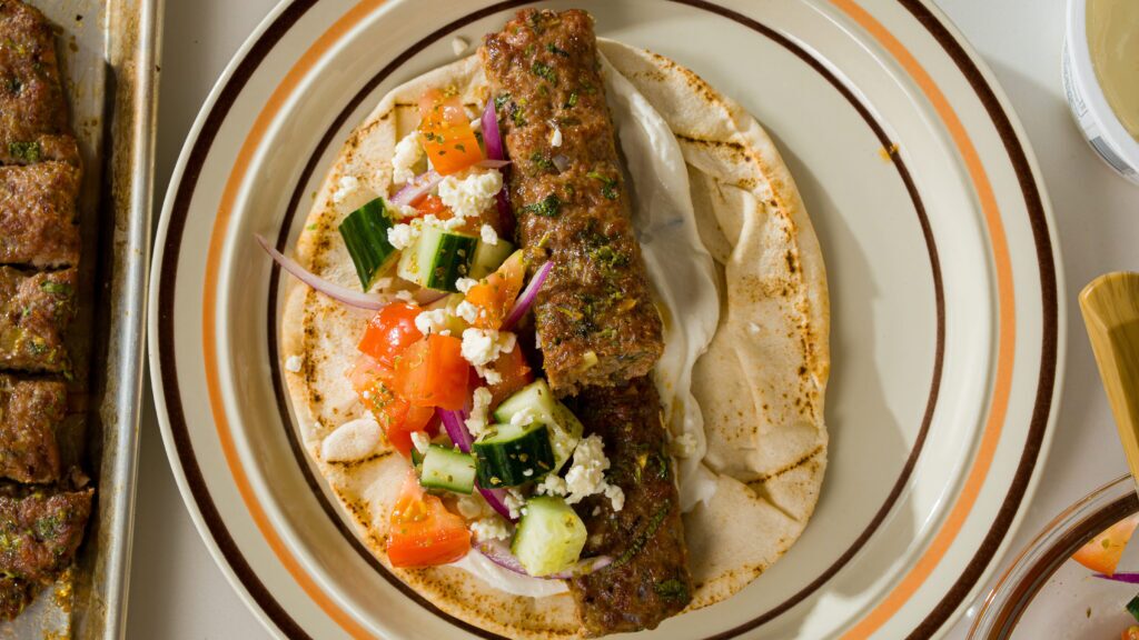 Chicken kebab on a pita with tzatziki and all the toppings.