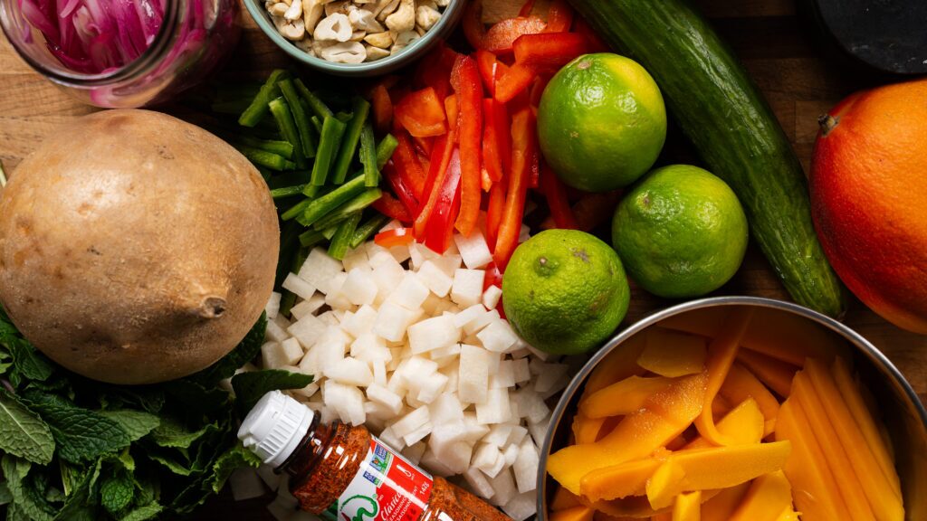 Jicama salad ingredients on a cutting board.