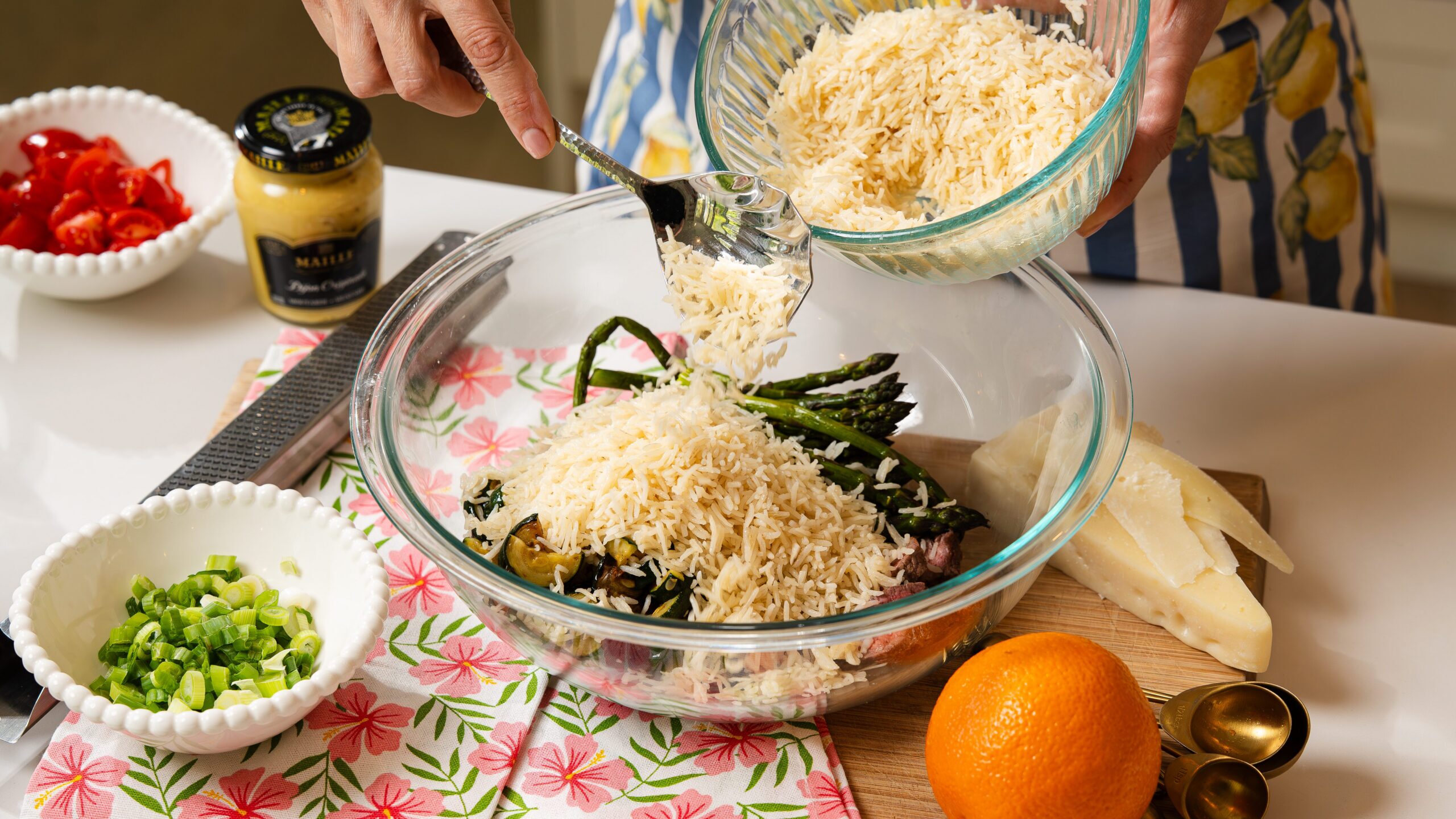 Adding rice to a mixing bowl to make a delicious steak salad recipe.