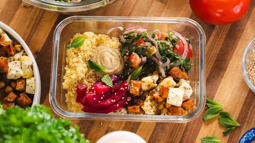 Mediterranean salad bowl on a counter with fresh veggies and grains.