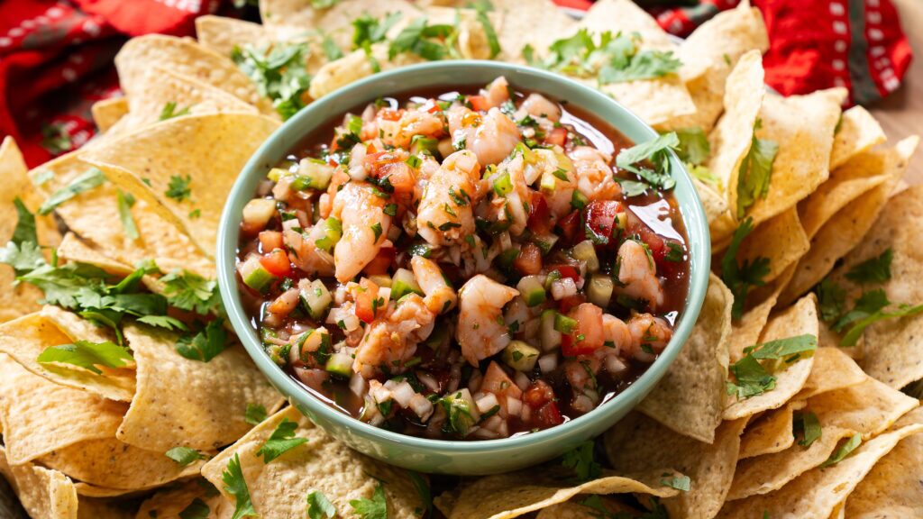 Shrimp cocktail on a bowl with tortilla chips all around.