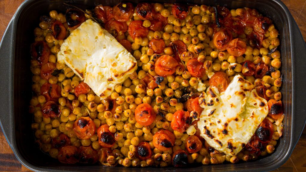Roasted chickpeas with tomatoes and feta in a baking dish.