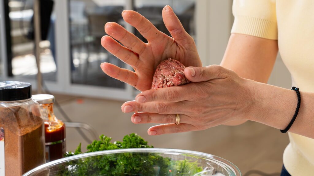 Rolling keftedes for a Greek meatball dish.