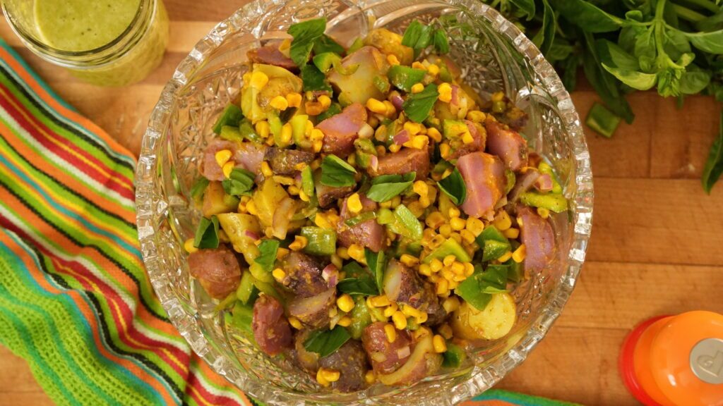 A corn salad with potato and jalape&ntilde;o in a large serving bowl.