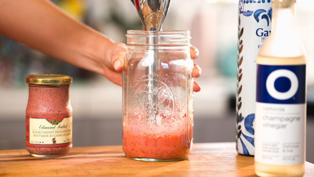 Emulsifying a strawberry vinaigrette in a mason jar.