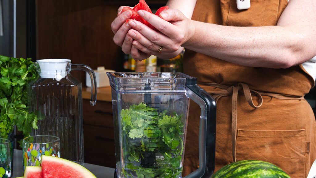 Adding watermelon to a blender to make a delicious watermelon aqua Fresca!