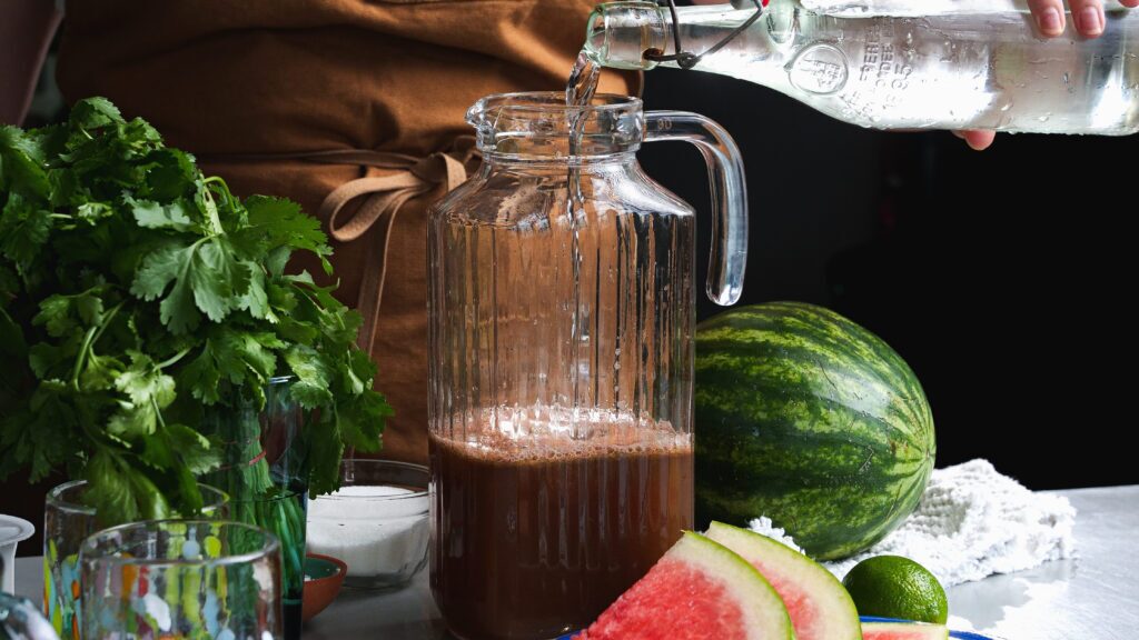 Adding water to a watermelon aqua Fresca recipe.