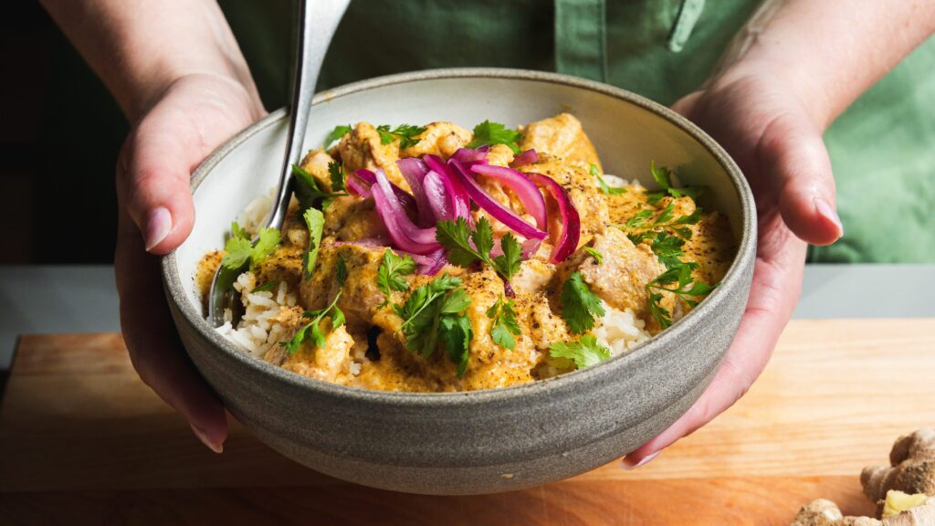 Mango chicken in a bowl with a fork.