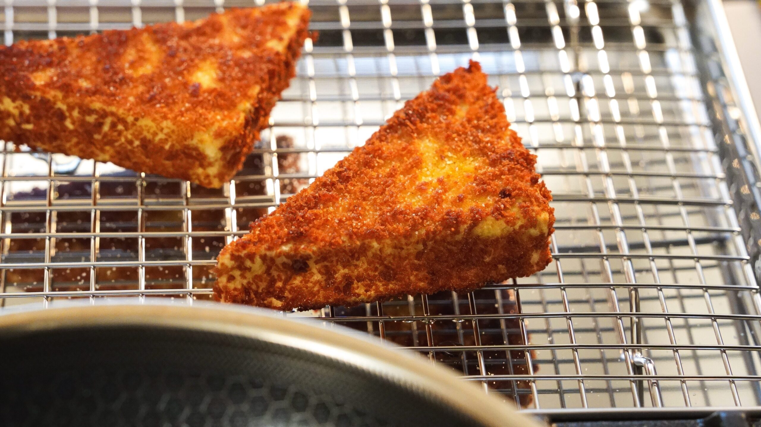 Crispy fried tofu on a wire rack.