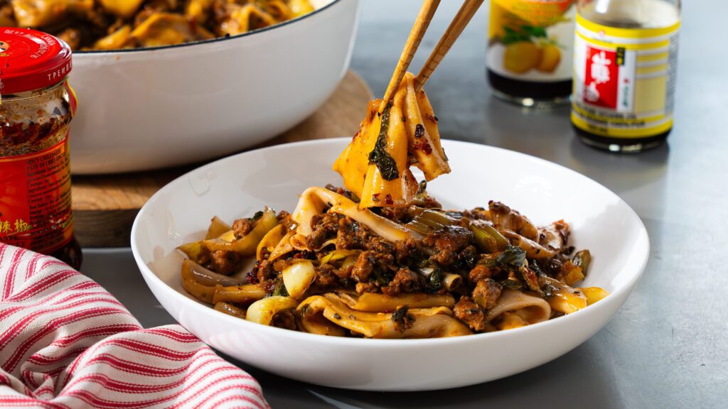 Dumpling noodle bowl with chopsticks.
