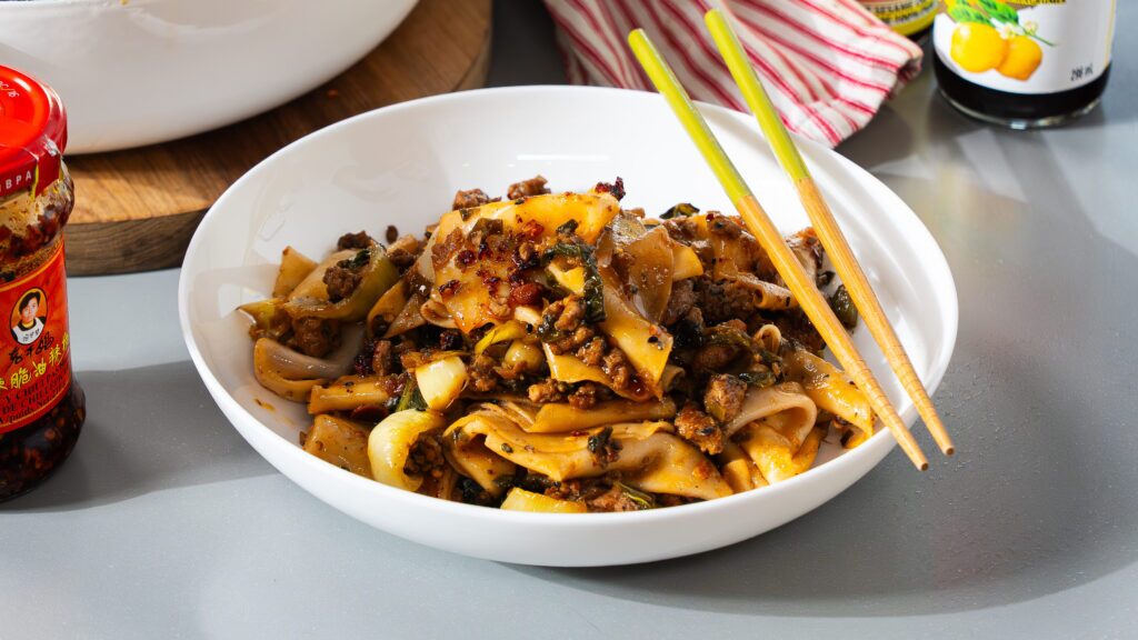 Pork dumpling noodle bowl recipe with chopsticks on the side.