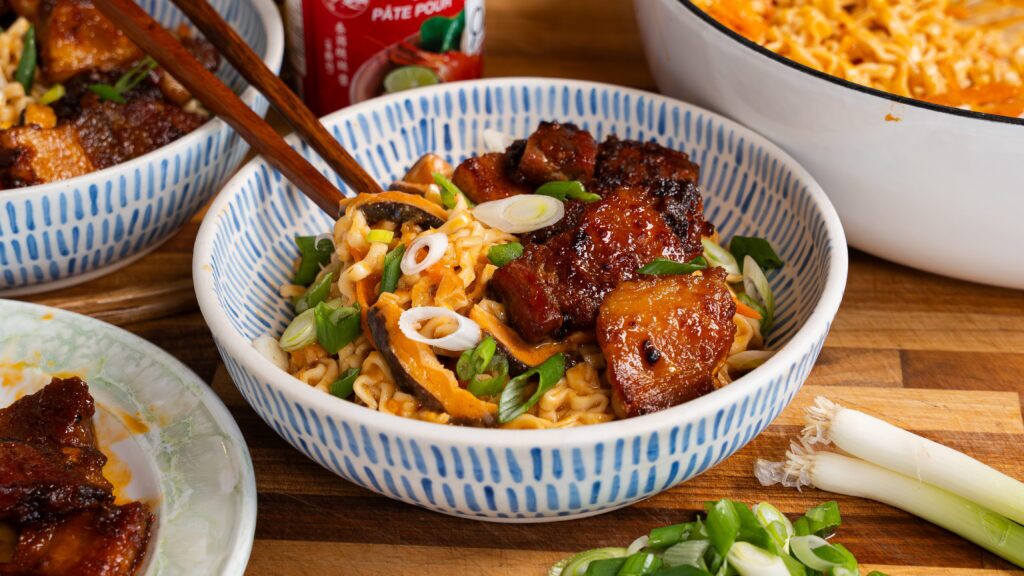 Pork belly ramen noodles in a bowl with green onion.