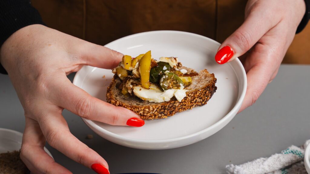Cream cheese and olive spread with honey and lemon on a piece of bread.