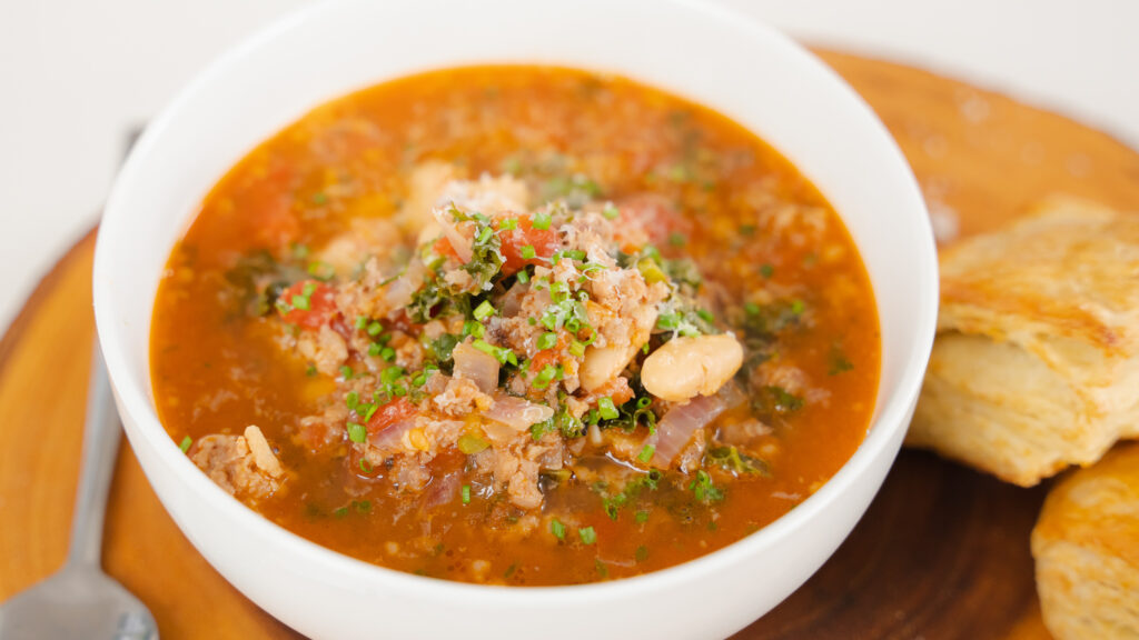 Sausage Kale and White Bean Soup in a white bowl 