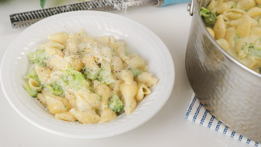 A white bowl of Broccoli mac and cheese