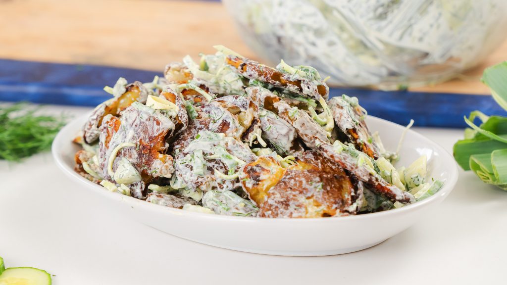 A close up of the Smash Potato Salad in a big white oval bowl.