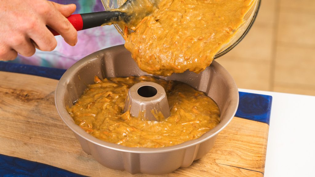 Carrot Bundt Cake batter binf poured into a fluted bundt pan