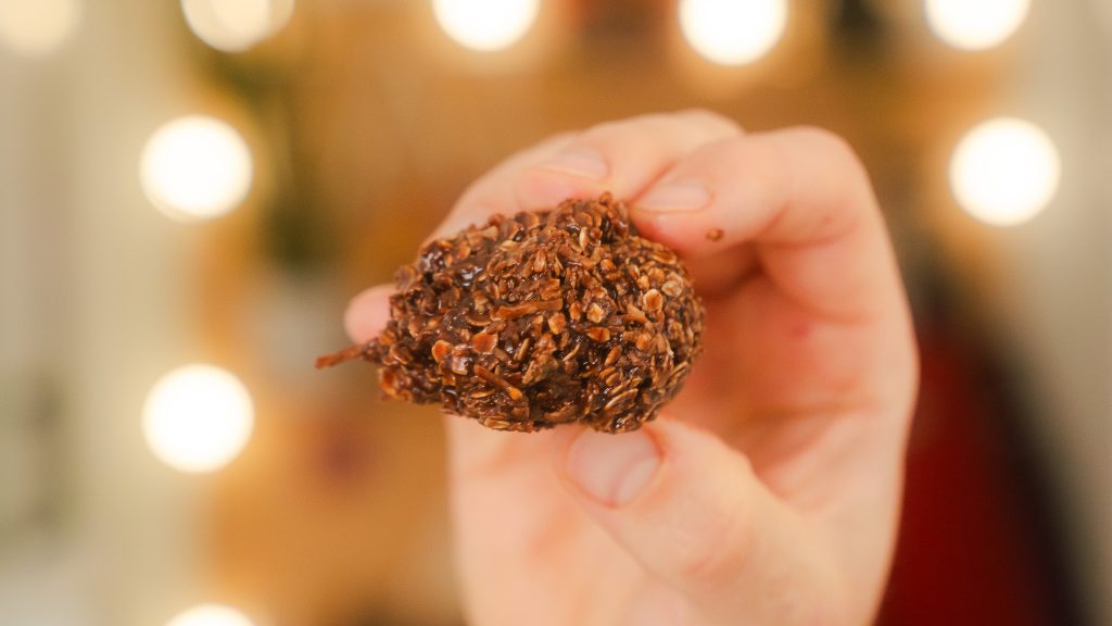 A close up shot of Chocolate Coconut Haystacks being held in one hand.