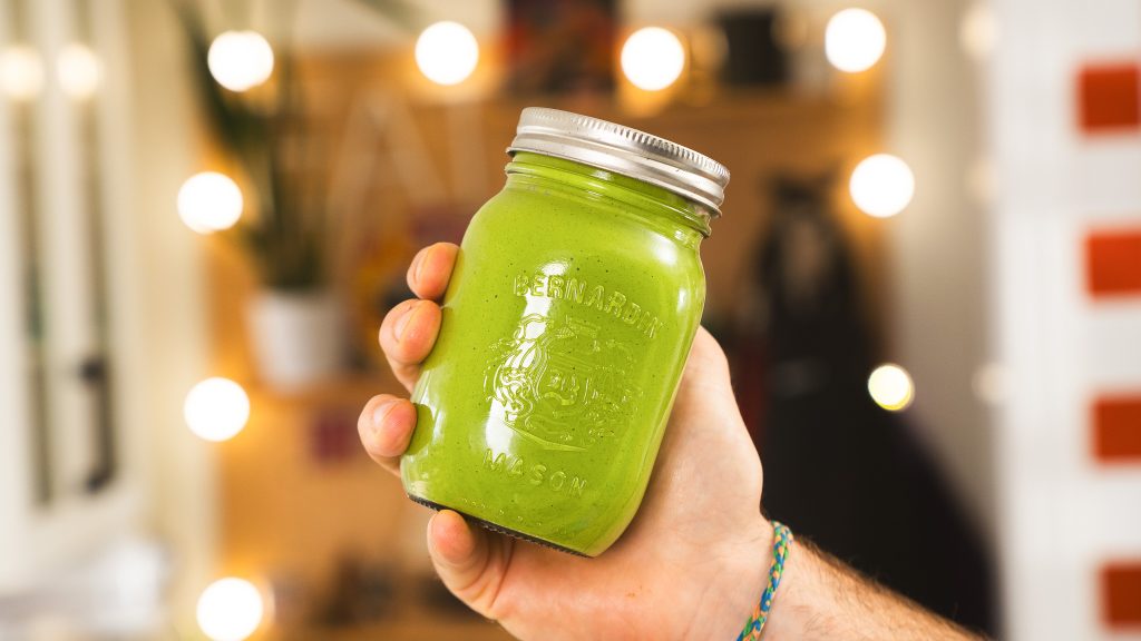 A close up shot of a vibrant, green mason jar full of shkug.