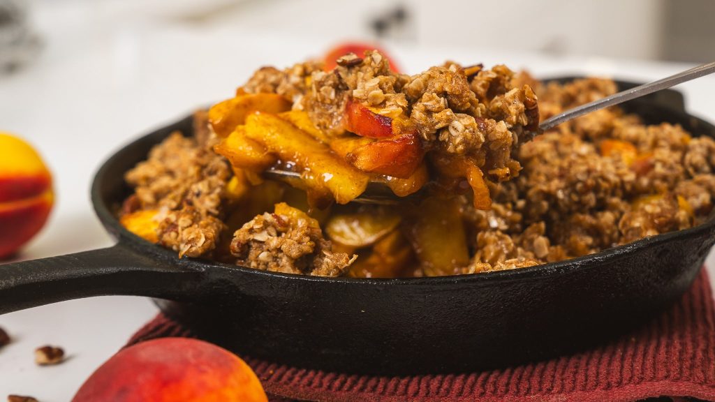 side angle of peach crumble being scooped