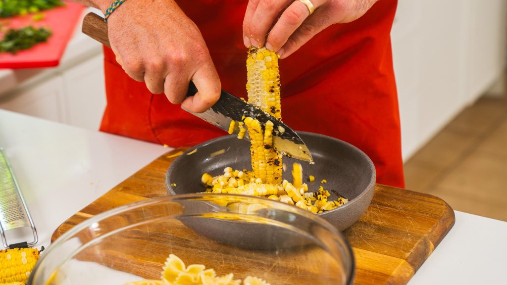 knife cutting corn off of cob