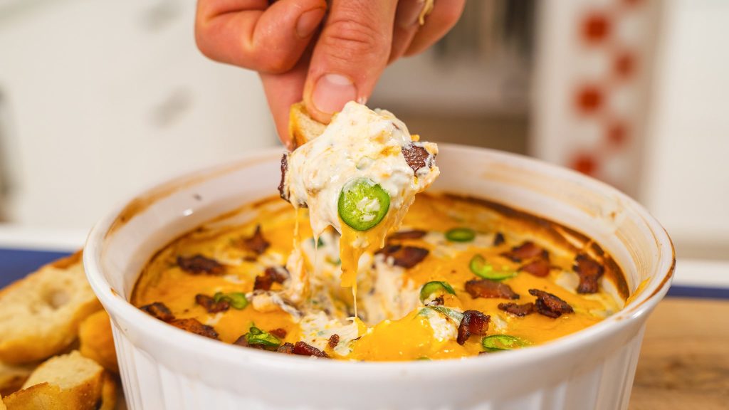 close up of hand dipping chip into dip