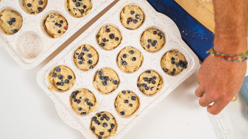 overhead shot of blueberry muffins in muffin ton before being baked.