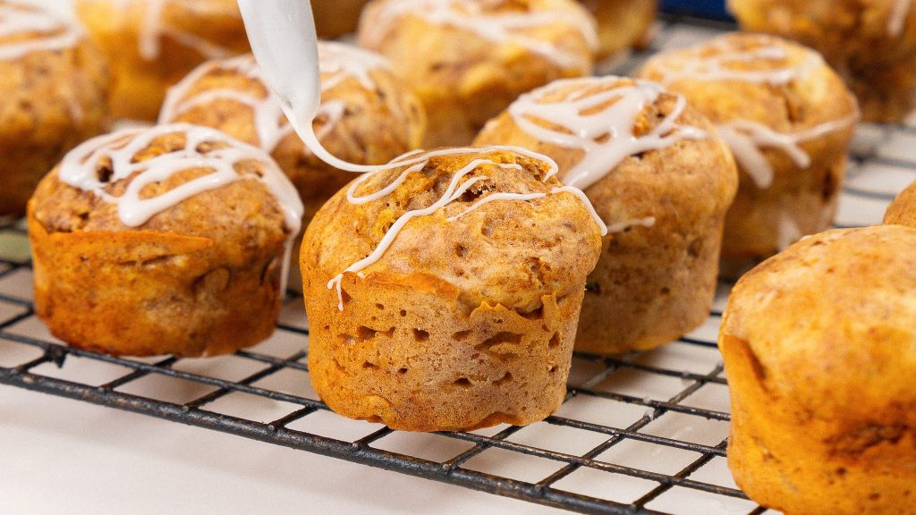 cinnamon cottage cheese muffin being topped with icing from a spoon