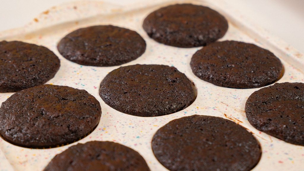 side angle shot of baked cupcakes sitting in muffin tin after baking