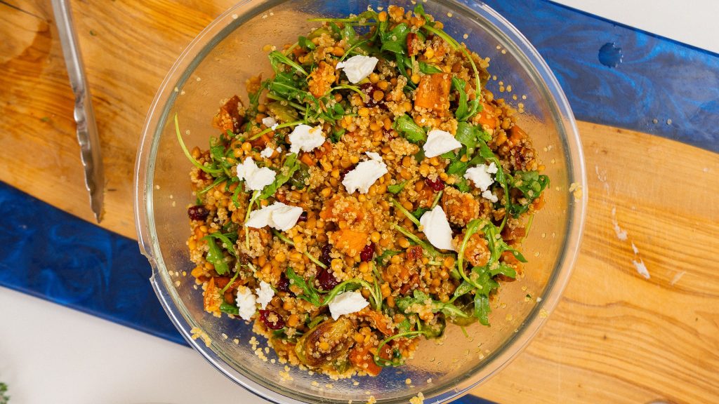glass bowl with harvest salad. topped with goats cheese