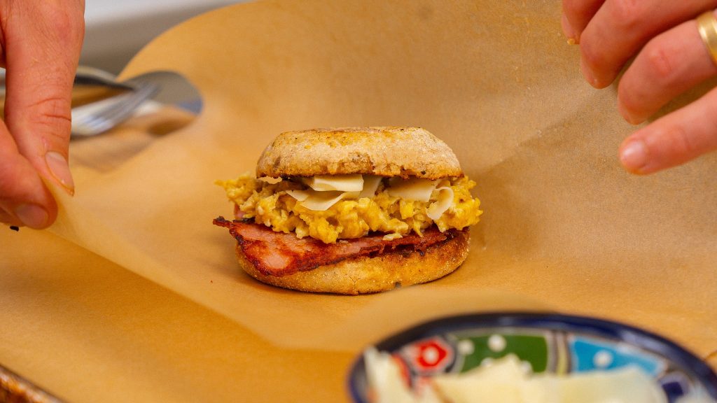 breakfast sandwich getting wrapped in parchment paper