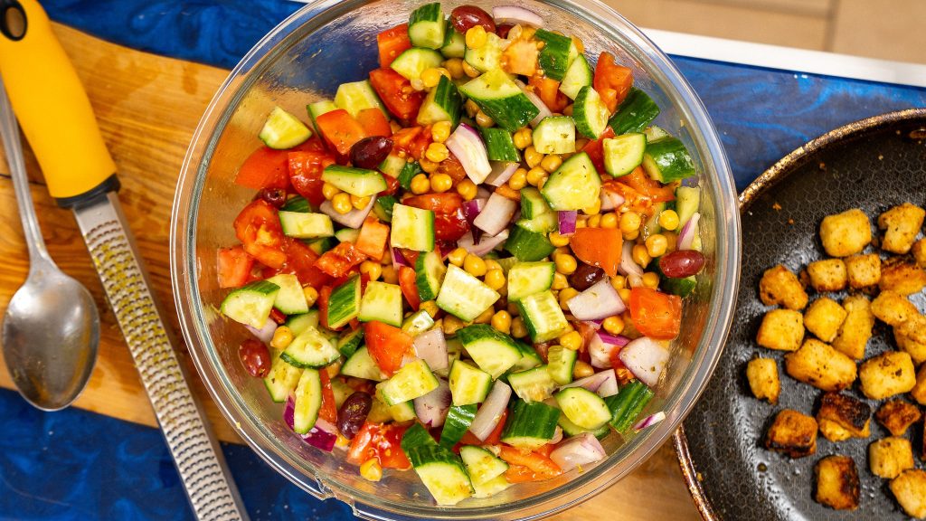 top down view of greek salad in large clear bowl