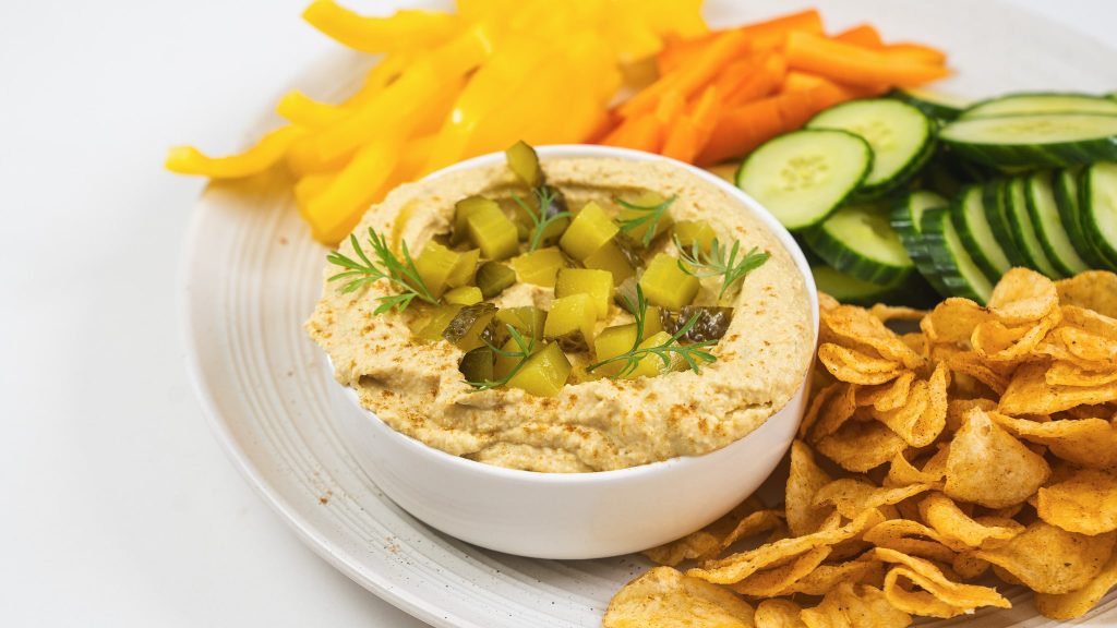 side angle shot of dill pickle hummus in bowl