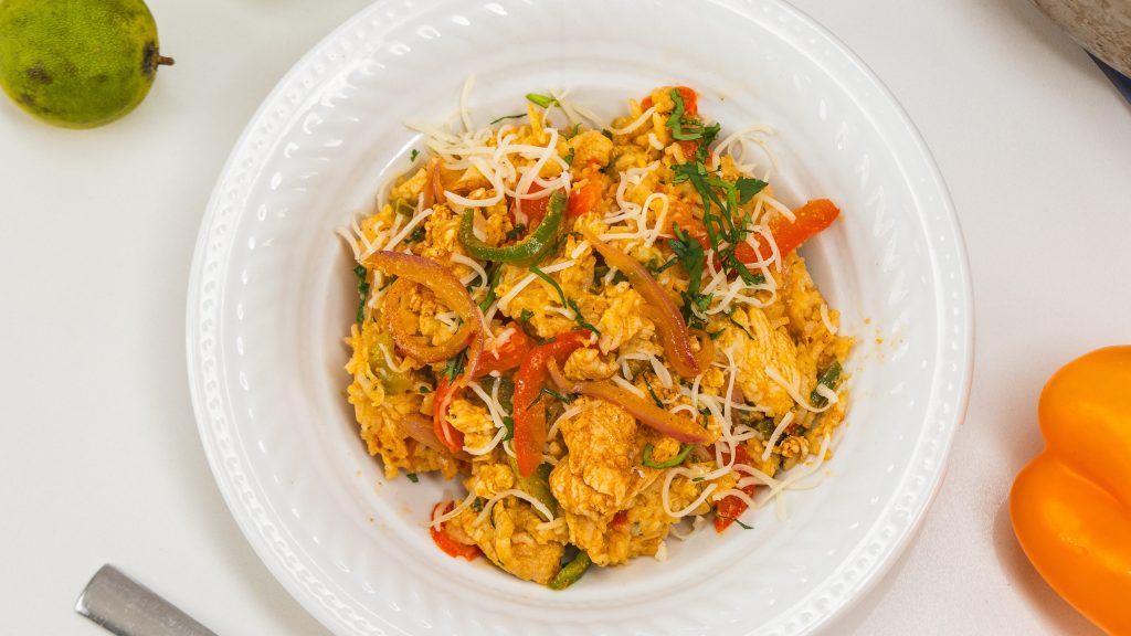 Chicken fajita rice bowl in a large white bowl, sitting on a counter top.