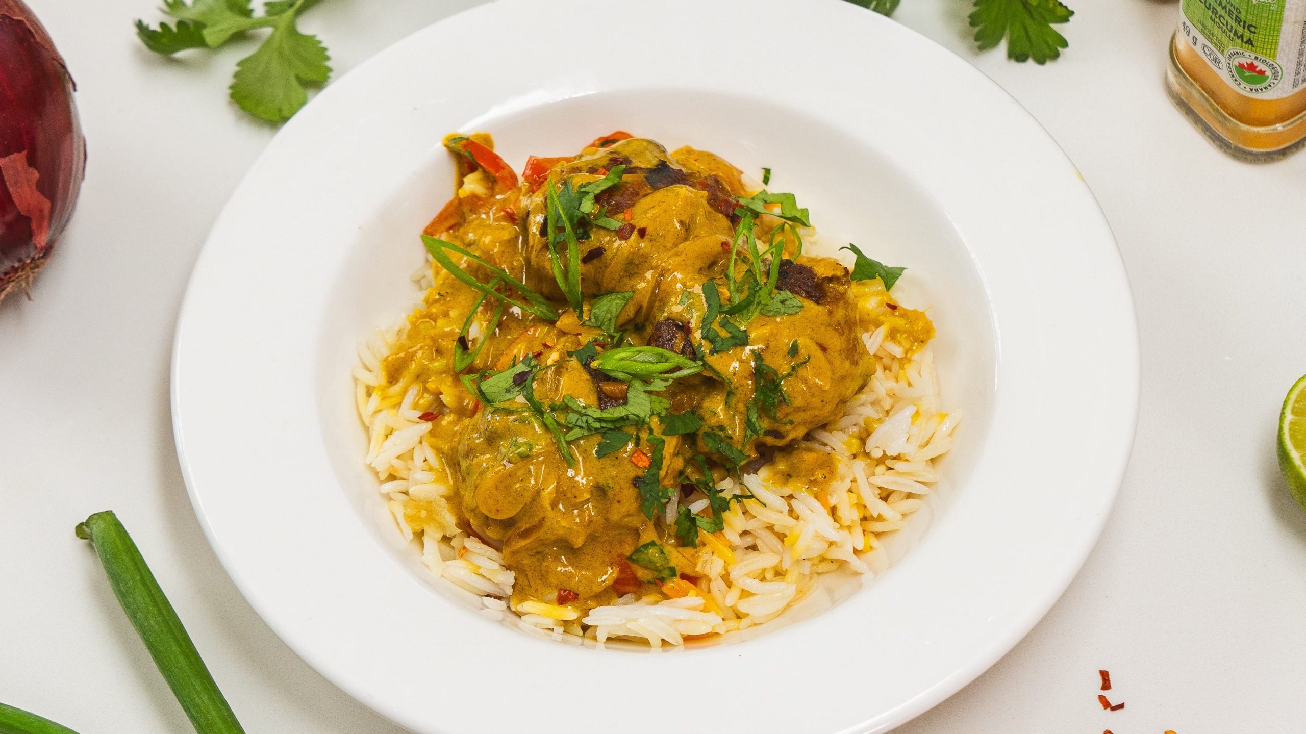Thai chicken meatballs in a white bowl over a bed of rice.