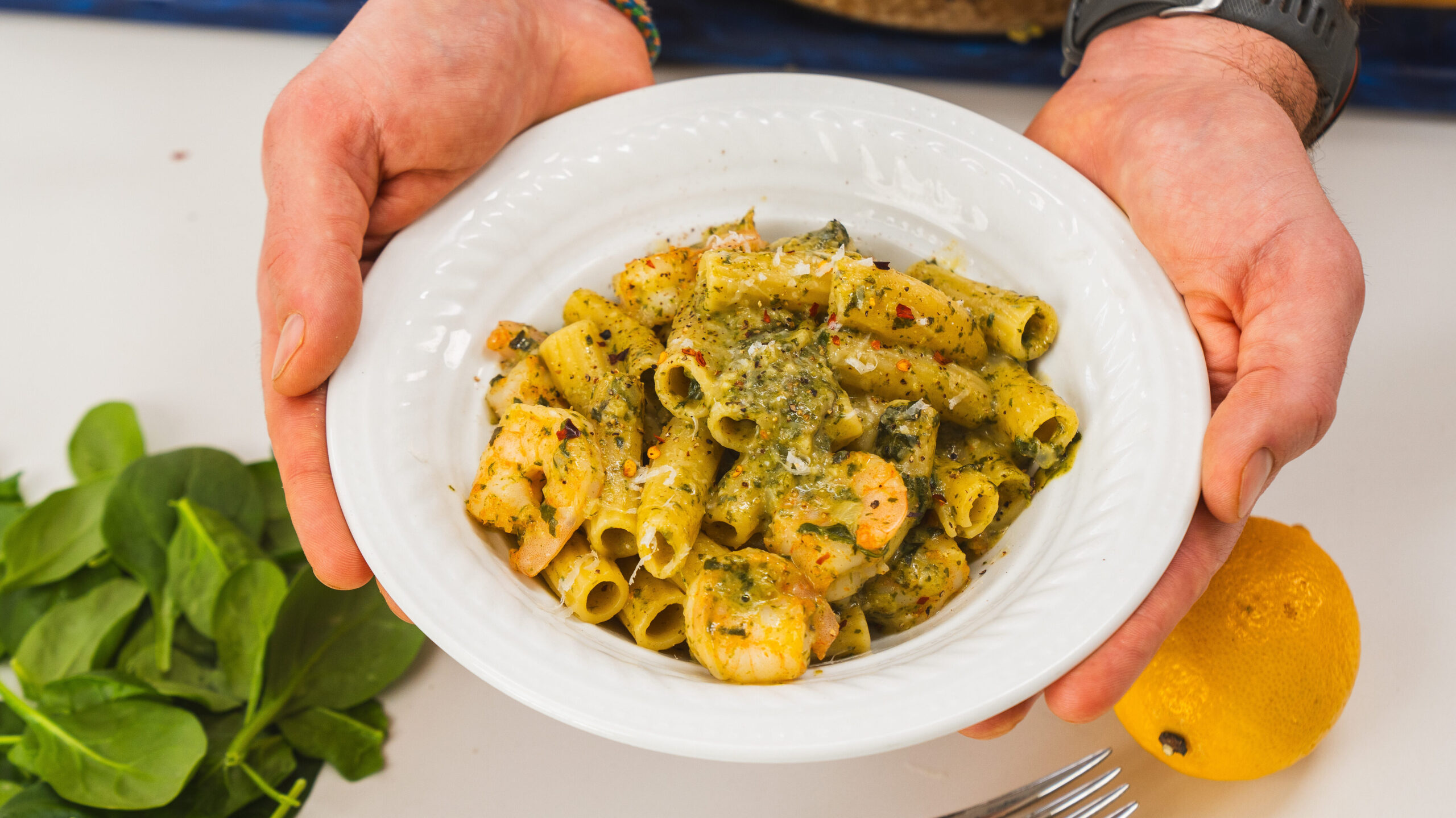 hands holding a white bowl filled with Marry me Shrimp Pasta