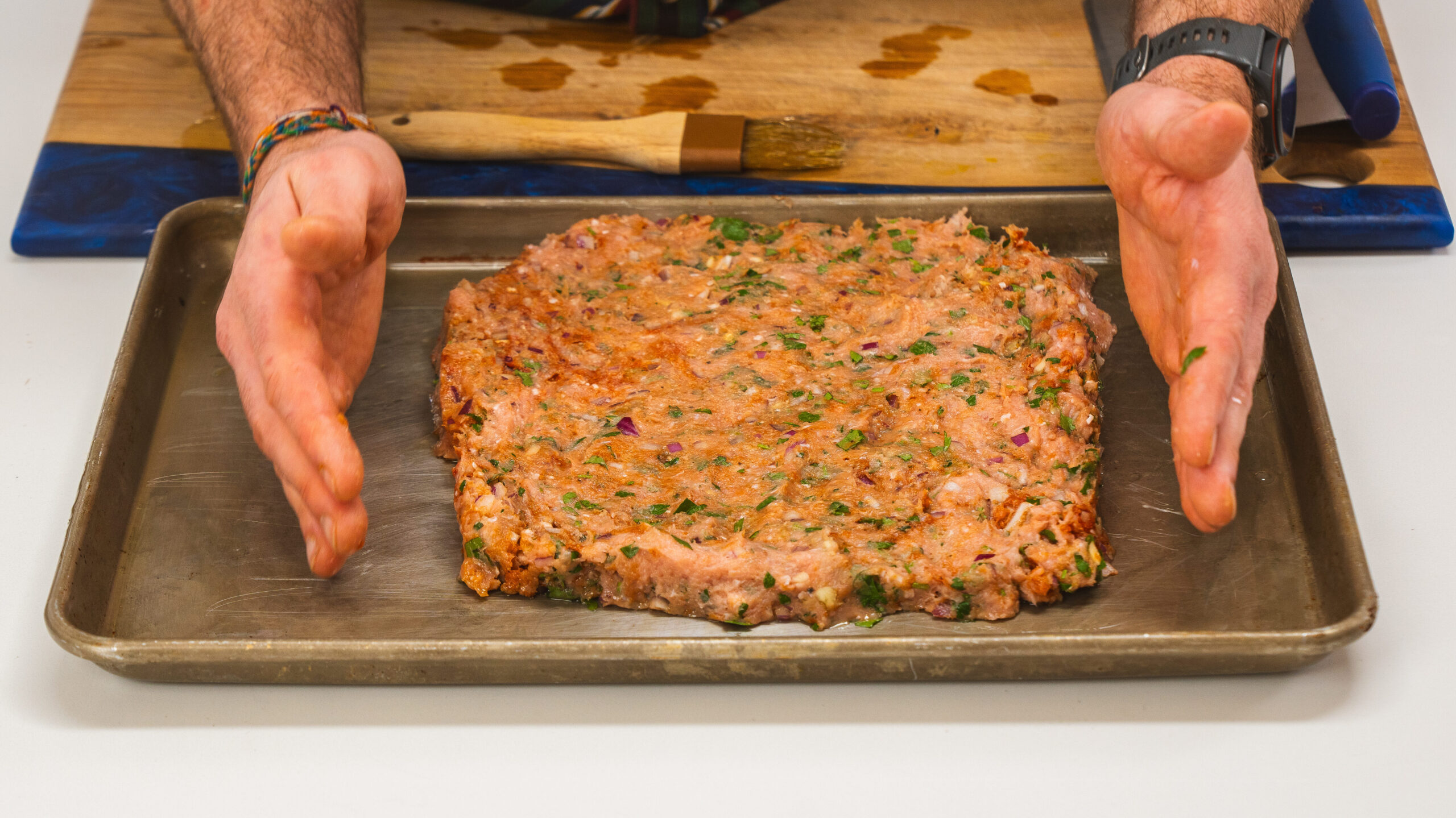 A sheet pan chicken recipe detailing ground chicken with spices and herbs, on a sheet pan.