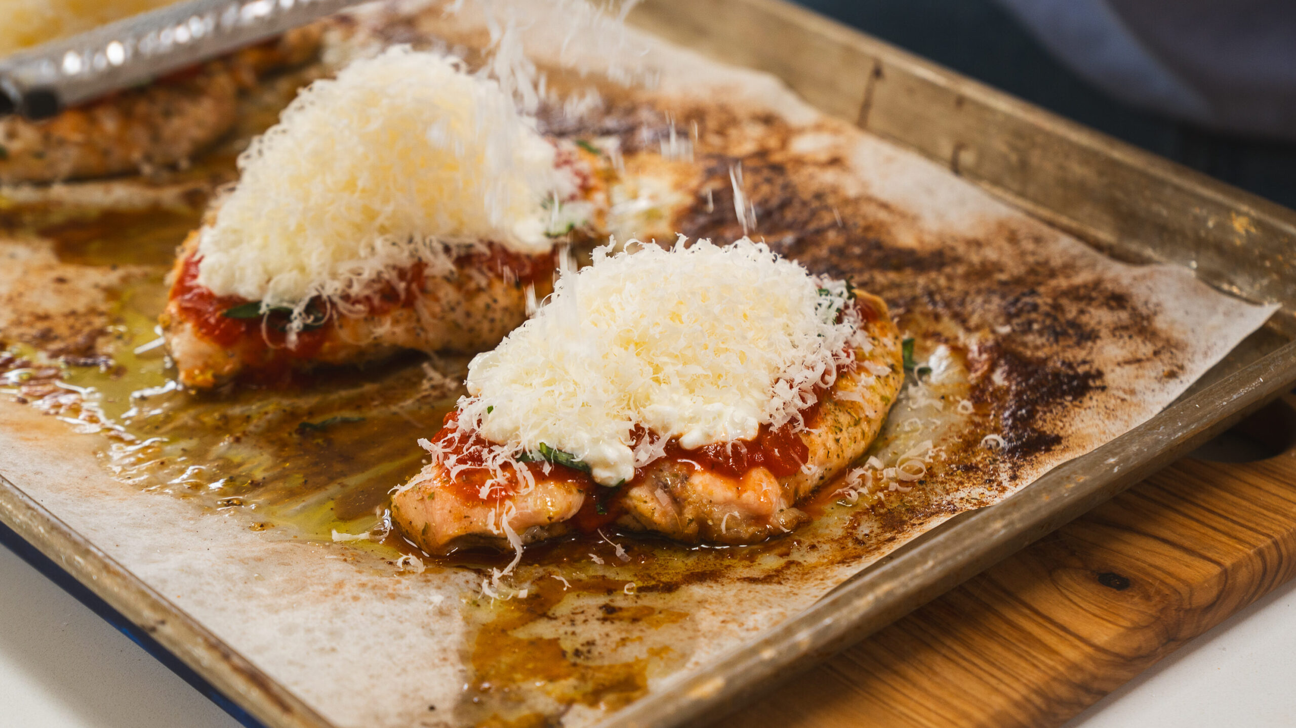High Protein Chicken Parmesan on a baking sheet.