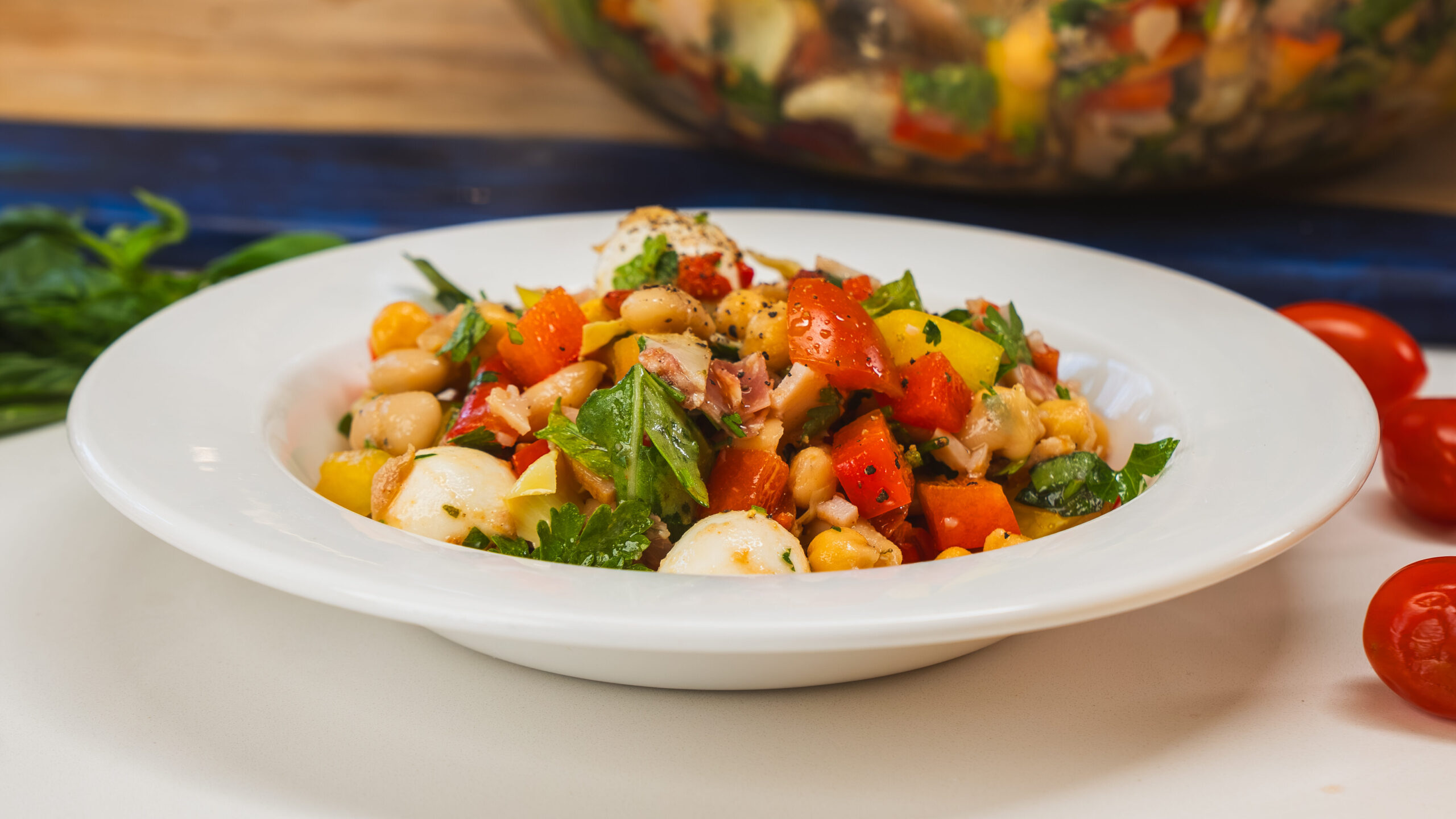 A chopped salad with beans, vegetables, and cjhopped salami.
