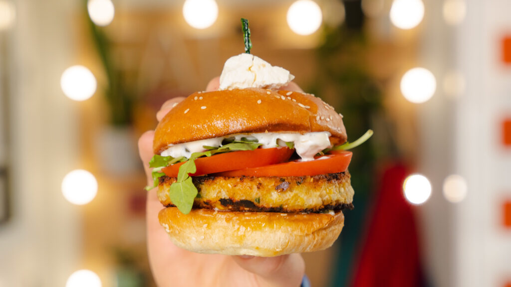 Chickpea veggie burger being held in someone's hand.