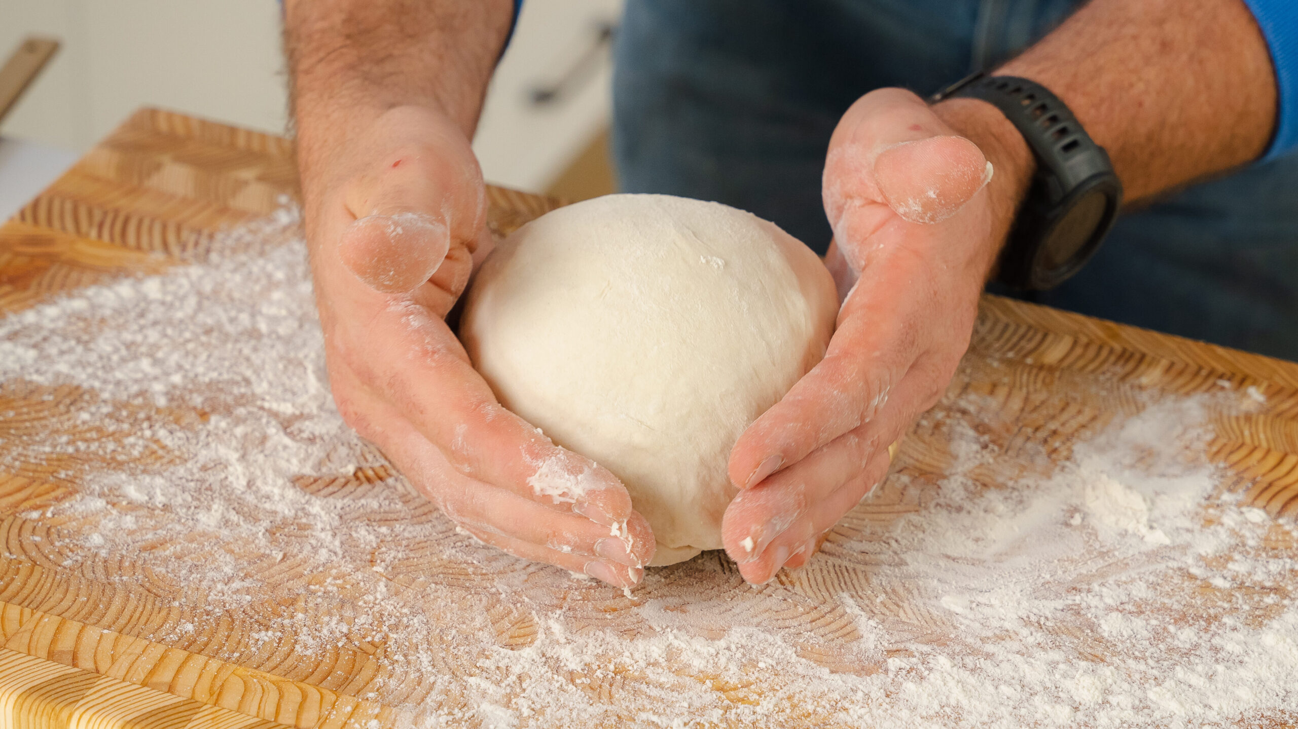 A delicious and easy homemade bread loaf being shaped on a floured surface.