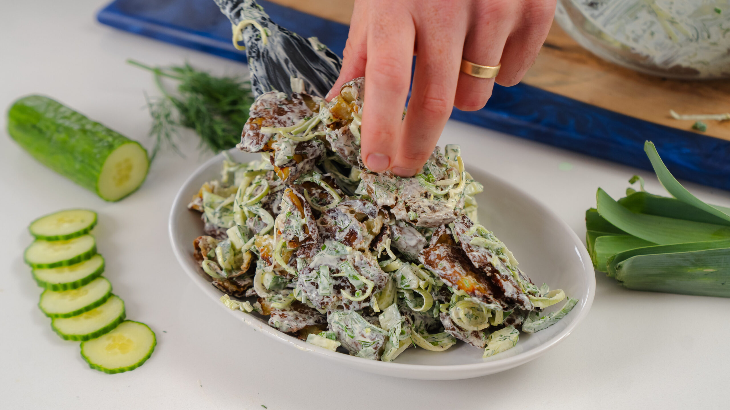Smashed potato salad being plated.